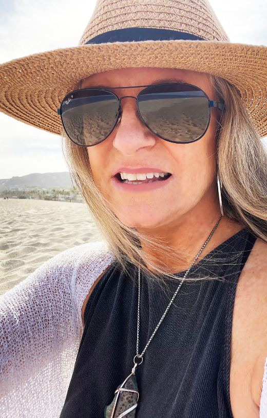 Vicki Murphy at a beach with sunglasses on